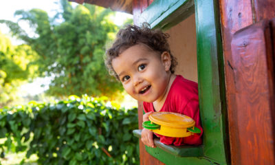 Criança na janela de casinha de madeira